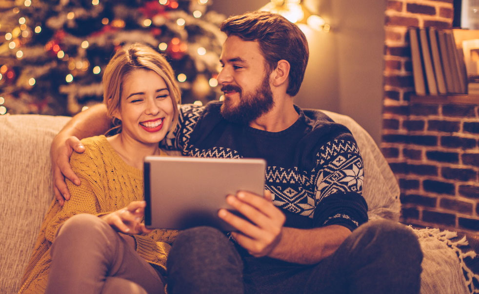 Image de deux personnes heureuses avec une tablette pour les fêtes - Bouygues Telecom