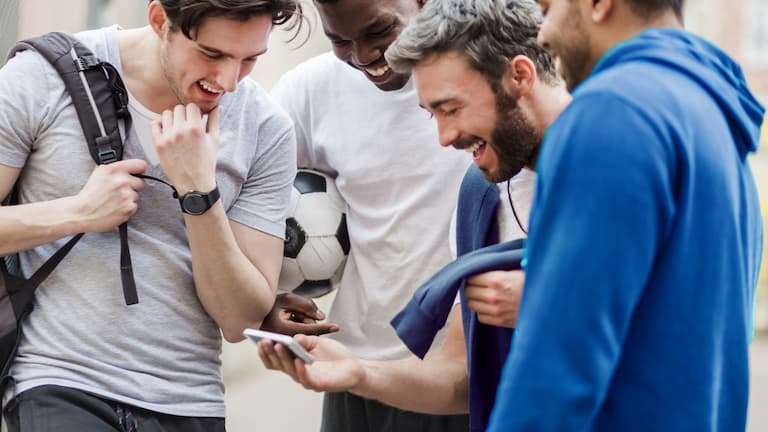 Amis regardant un match sur leur smartphone