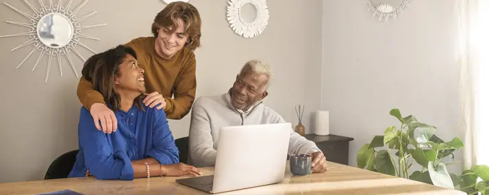 Ado avec ses parents, tous les trois sourient devant l’ordinateur