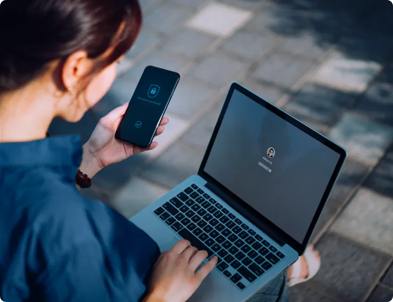 Femme sur son smartphone, l’écran affiche un système de cybersécurité