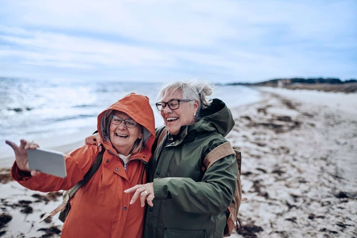 Visuel de deux femmes agées en camping prenant un selfie