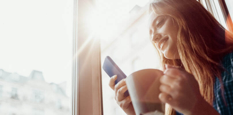 femme buvant café et regardant son smartphone