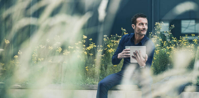 homme d'affaire sur tablette pose-cafe dans jardin