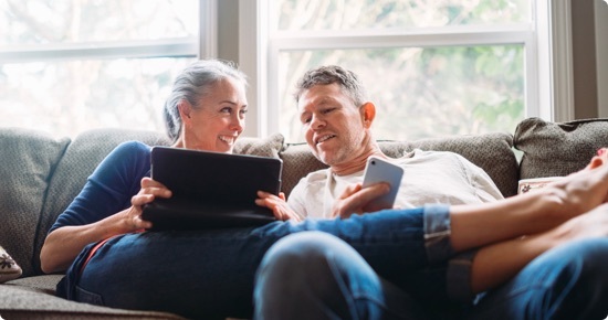 visuel couple agé utilisant une tablette et un smartphone